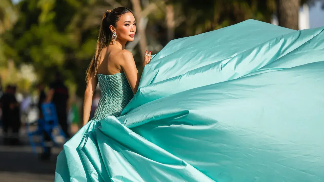 Elegante Dame im mintgrünen Ballkleid, das den Black Tie Dresscode für Damen perfekt verkörpert. Ihr Kleid weht im Wind.