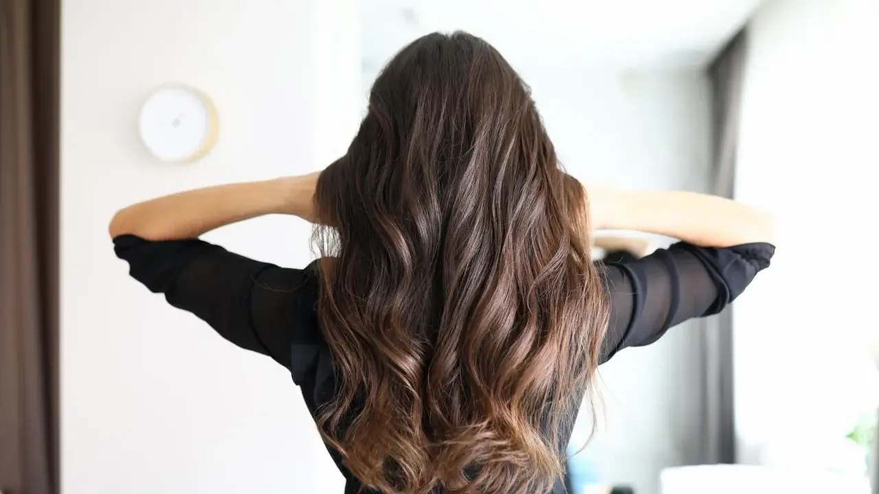 Frauenhaar mit butterfly haircut mittellang, wellig und braun.