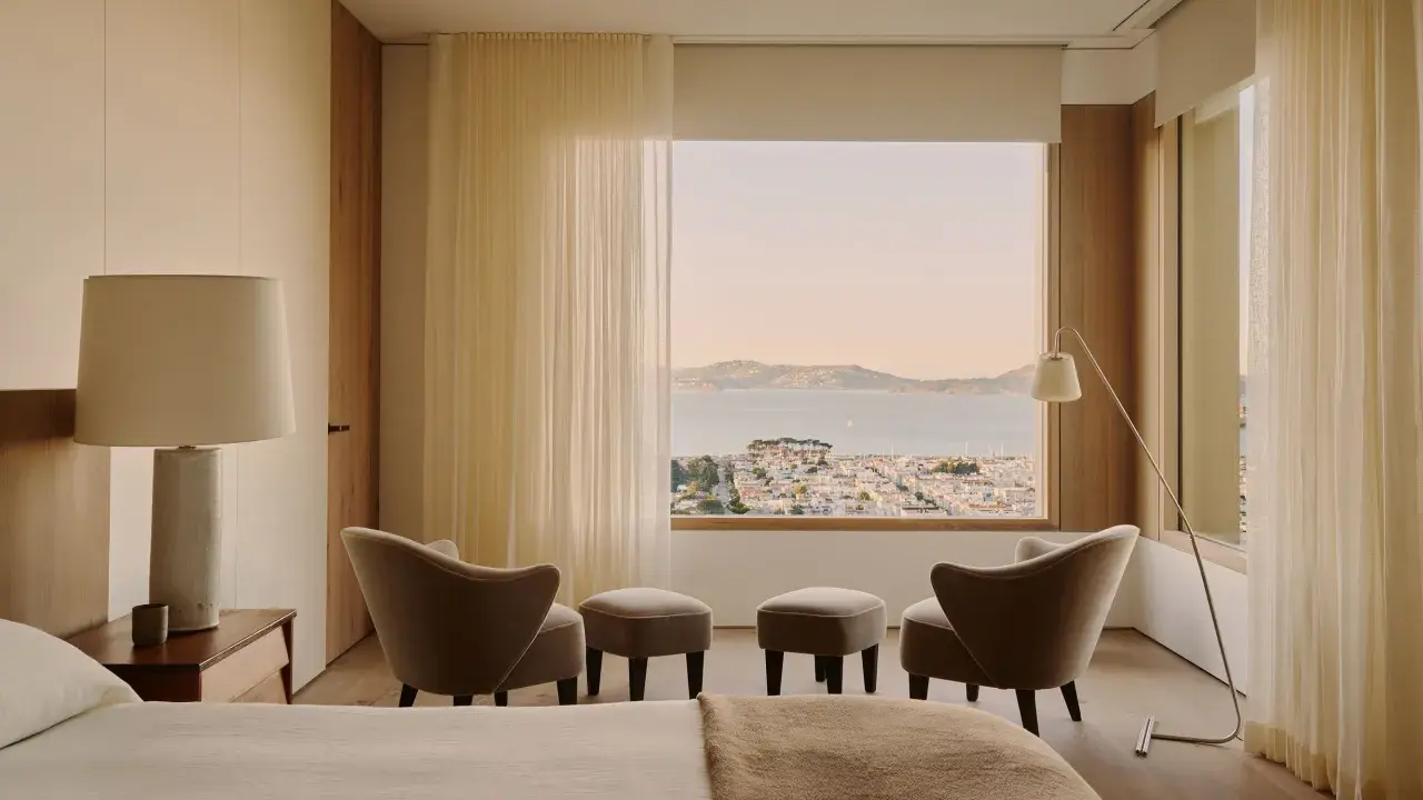 Ein Schlafzimmer mit Blick auf die Stadt und das Meer, gestaltet im Stil einer Feng Shui Wohnung. Sanfte Farben und natürliche Materialien schaffen Harmonie.
