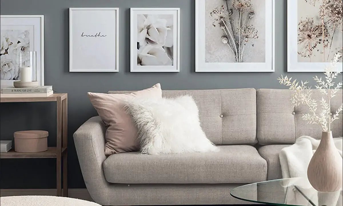 Stilvolle wandgestaltung wohnzimmer hinter couch mit floralen Bildern und einem gemütlichen Sofa.