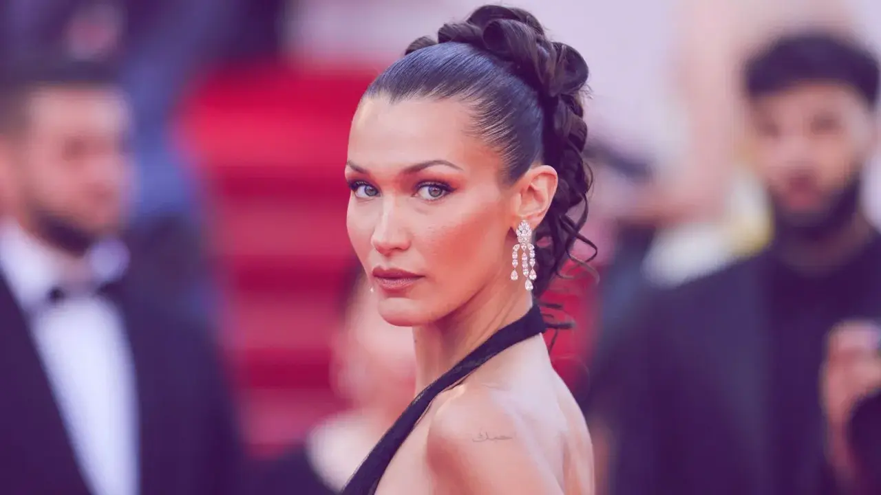Bella Hadid präsentiert einen eleganten, sleek zopf mit funkelnden Ohrringen auf dem roten Teppich.