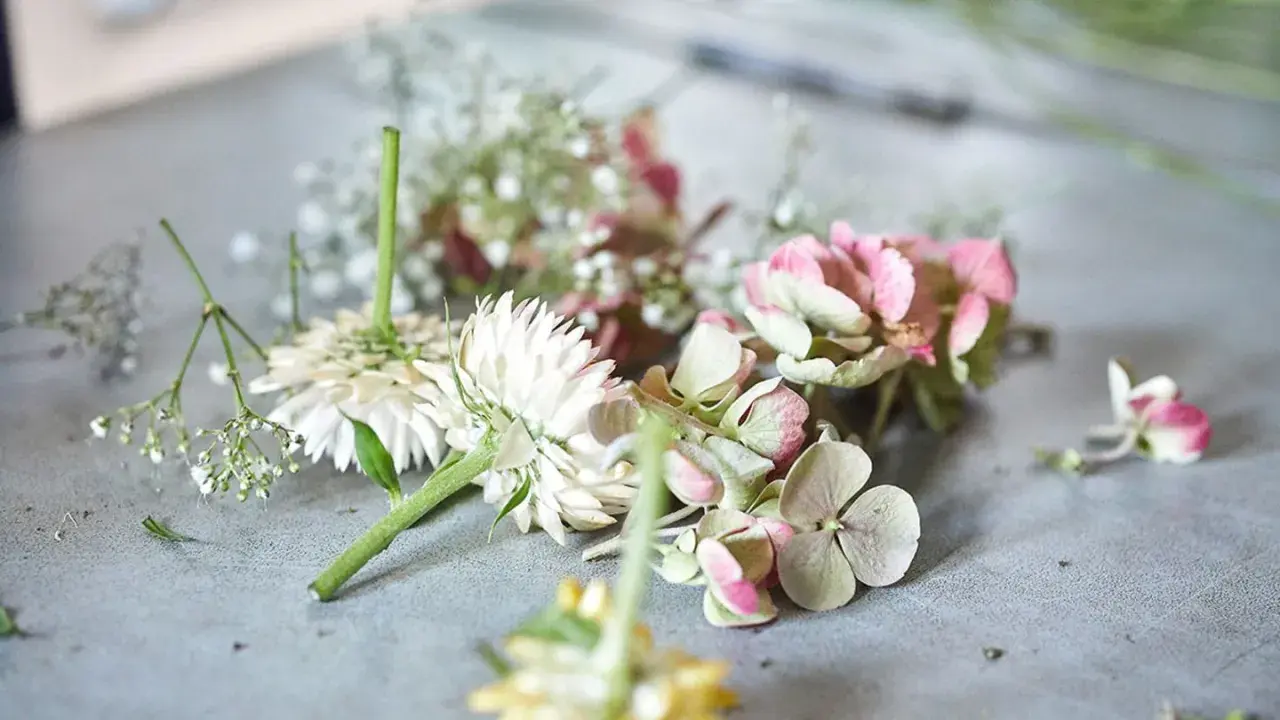 Zutaten für einen Blumenkranz: weiße Blüten, rosa Hortensien und zarte Schleierkräuter liegen bereit.