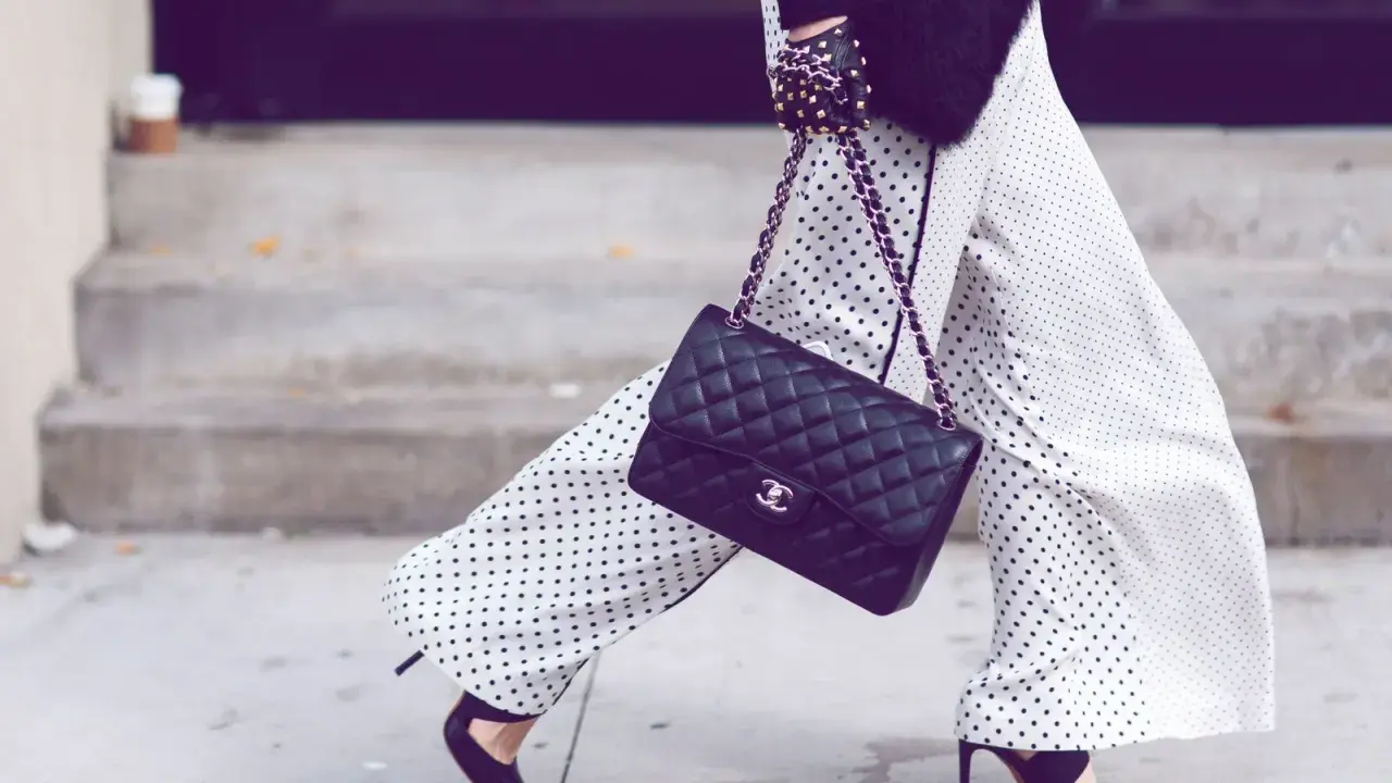Chic polka dot palazzo hose kombinieren mit schwarzer Tasche und High Heels.