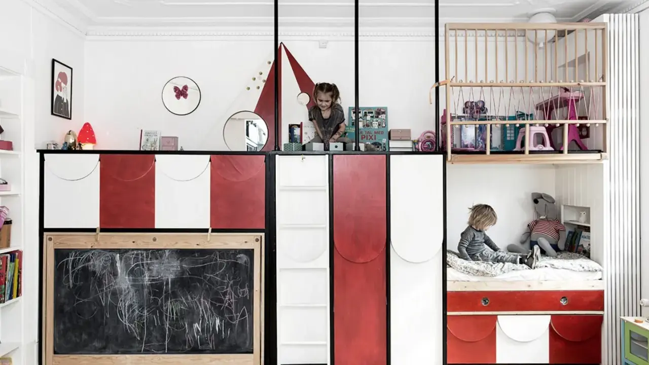 Kreative geschwisterzimmer ideen: Kinder spielen in einem bunten Zimmer mit Hochbetten, Rutsche und Tafel.