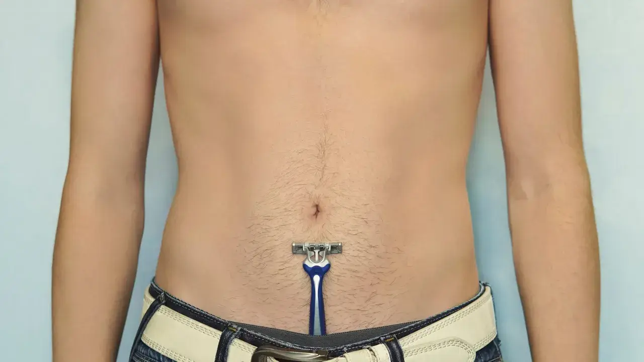 Ein Mann mit einem Rasierer im Bauchbereich, bereit für die intim rasur mann.