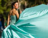 Elegante Dame im mintgrünen Ballkleid, das den Black Tie Dresscode für Damen perfekt verkörpert. Ihr Kleid weht im Wind.