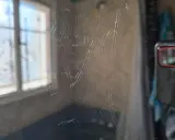 Zahlreiche Kratzer auf einer Glasoberfläche, die auf eine Politur warten. Im Hintergrund ist ein Fenster mit Jalousien zu sehen.