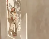 Frau in beiger Hose und Jacke, die lässig posiert. Ein Beispiel, wie man beige Hose kombinieren kann für einen stilvollen Look.