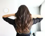 Frauenhaar mit butterfly haircut mittellang, wellig und braun.