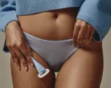 Frauen intimrasur: Ein Trend, der Selbstpflege und Körpergefühl vereint. Eine Hand hält einen Rasierer, bereit für die Pflege.