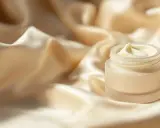 Creme in einem Glas auf seidigem Stoff.