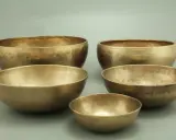 Fünf goldene Klangschalen, bereit für die Messing reinigen. Ihre Oberflächen schimmern im Licht.