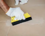 Mit einem gelben Spachtel werden die **Fliesen Fugen reinigen** und mit neuem Material gefüllt.