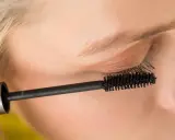 Ein Auge wird mit Mascara für ein leichtes Sommer Make-up betont. Die Bürste trennt und verlängert die Wimpern.