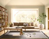Gemütliche Anordnung Sofa Wohnzimmer mit Bücherregal, Kamin und großem Fenster.