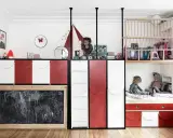 Kreative geschwisterzimmer ideen: Kinder spielen in einem bunten Zimmer mit Hochbetten, Rutsche und Tafel.