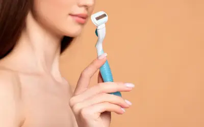 Eine Frau hält einen Rasierer, bereit für die Intimrasur.