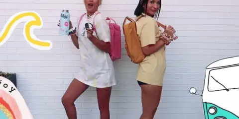 Zwei vsco girls mit Rucksäcken und Wasserflaschen, bereit für ein Abenteuer.