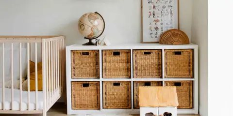 Ordentliches Kinderzimmer mit Gitterbett, Spielzeugkiste, Globus und Wandbild. Alles griffbereit für den Nachwuchs.