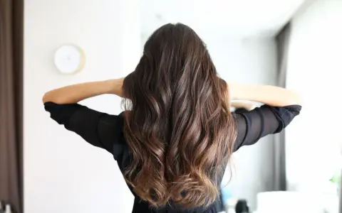 Frauenhaar mit butterfly haircut mittellang, wellig und braun.