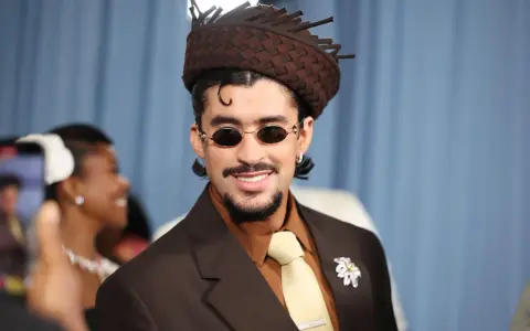 Bad Bunny mit braunem Anzug und auffälligem Hut, bereit für den Met Gala 2026.