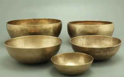 Fünf goldene Klangschalen, bereit für die Messing reinigen. Ihre Oberflächen schimmern im Licht.