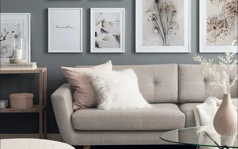 Stilvolle wandgestaltung wohnzimmer hinter couch mit floralen Bildern und einem gemütlichen Sofa.
