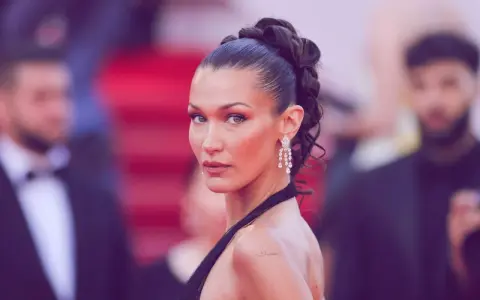 Bella Hadid präsentiert einen eleganten, sleek zopf mit funkelnden Ohrringen auf dem roten Teppich.