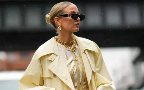 Chic low bun, perfect for managing frisuren fettige haare. Gold jewelry and sunglasses complete the stylish look.