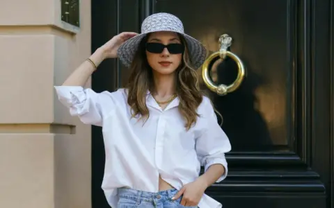 Stylisches Outfit: weiße Bluse, Jeans und Hut – perfekt, um an 20 Grad warmen Tagen gut auszusehen.