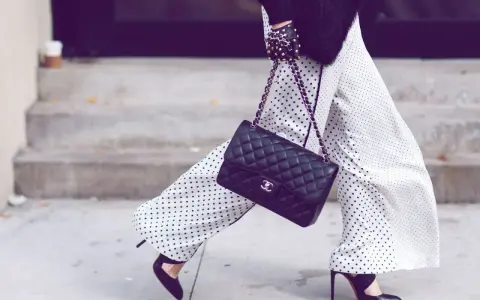 Chic polka dot palazzo hose kombinieren mit schwarzer Tasche und High Heels.