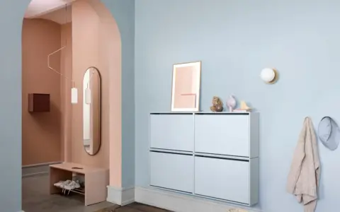 Schmalen dunklen Flur gestalten: Ein heller Schuhschrank und eine Sitzbank mit Spiegel schaffen Gemütlichkeit.