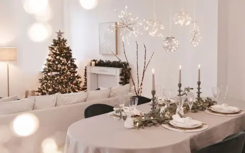 Festlich gedeckter Tisch mit Kerzen und Weihnachtbaum. Die Frage "ab wann weihnachtsdeko" stellt sich hier nicht, denn die Deko ist bereits da!
