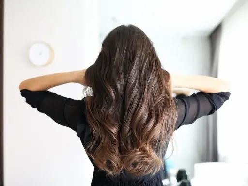 Frauenhaar mit butterfly haircut mittellang, wellig und braun.