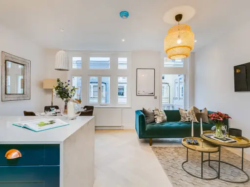 Ein tiefgrünes Sofa bildet den Mittelpunkt dieses stilvollen Wohnzimmers. Welche Farbe passt zu Petrol? Hier sehen wir warme Holztöne und dezente Muster, die das Petrol perfekt ergänzen.