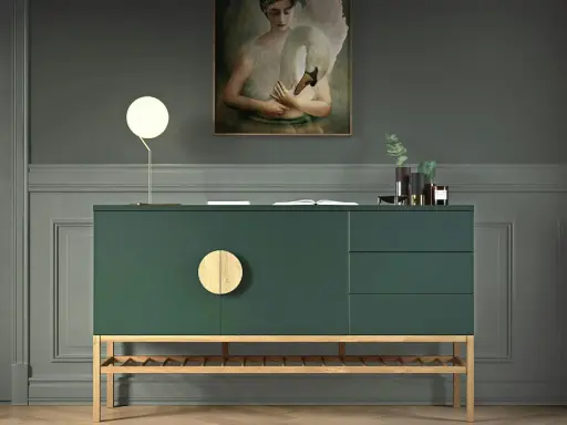 Ein grünes Sideboard mit Holzdetails, dekoriert mit einer Lampe, einem Buch und Vasen. Ein Gemälde mit einem Schwan hängt darüber.