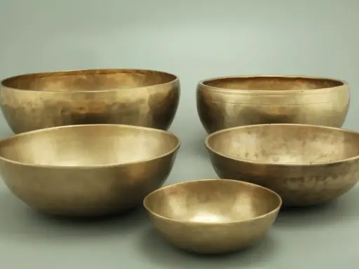 Fünf goldene Klangschalen, bereit für die Messing reinigen. Ihre Oberflächen schimmern im Licht.