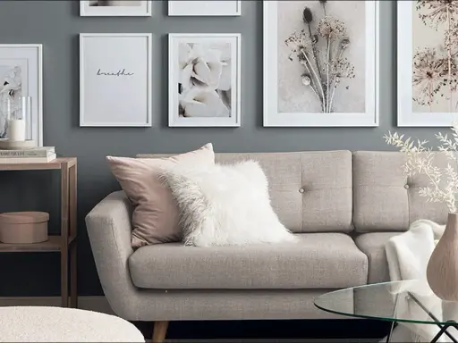 Stilvolle wandgestaltung wohnzimmer hinter couch mit floralen Bildern und einem gemütlichen Sofa.