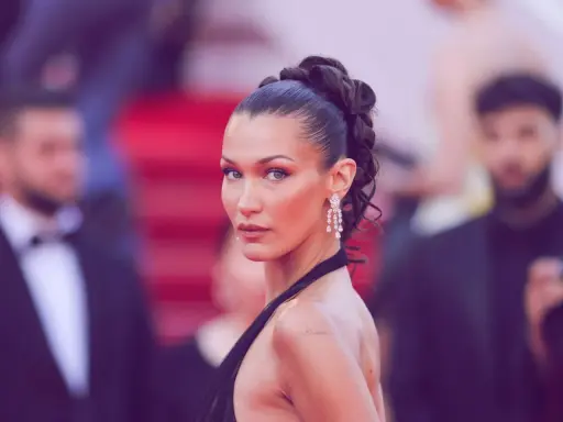 Bella Hadid präsentiert einen eleganten, sleek zopf mit funkelnden Ohrringen auf dem roten Teppich.