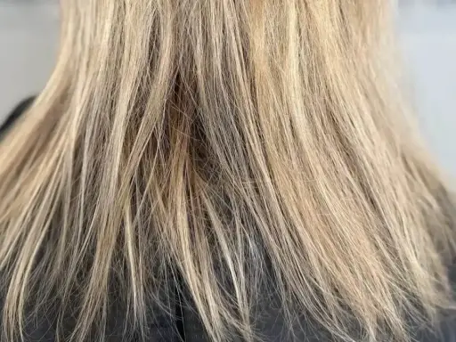 Glänzendes, blondiertes Haar, das nach der richtigen Pflege strahlt.