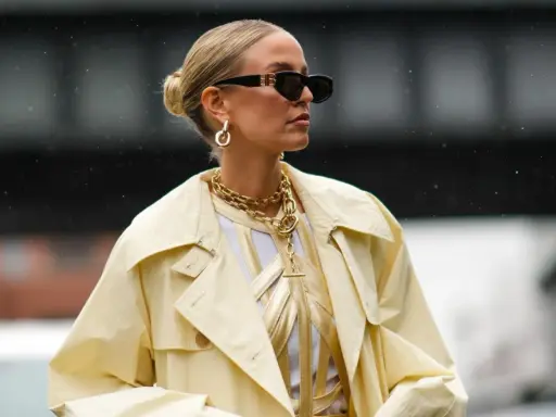 Chic low bun, perfect for managing frisuren fettige haare. Gold jewelry and sunglasses complete the stylish look.
