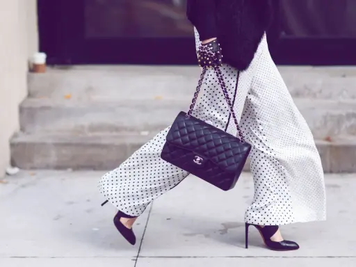 Chic polka dot palazzo hose kombinieren mit schwarzer Tasche und High Heels.