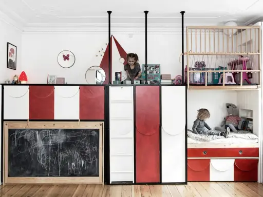 Kreative geschwisterzimmer ideen: Kinder spielen in einem bunten Zimmer mit Hochbetten, Rutsche und Tafel.