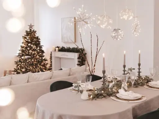 Festlich gedeckter Tisch mit Kerzen und Weihnachtbaum. Die Frage "ab wann weihnachtsdeko" stellt sich hier nicht, denn die Deko ist bereits da!