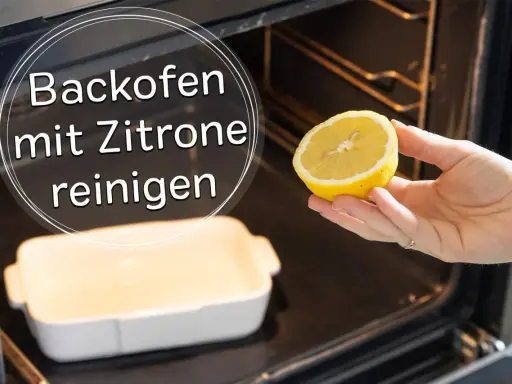 Backofen reinigen mit Zitrone: Eine Hand hält eine Zitronenhälfte über einer Auflaufform im dunklen Backofen.