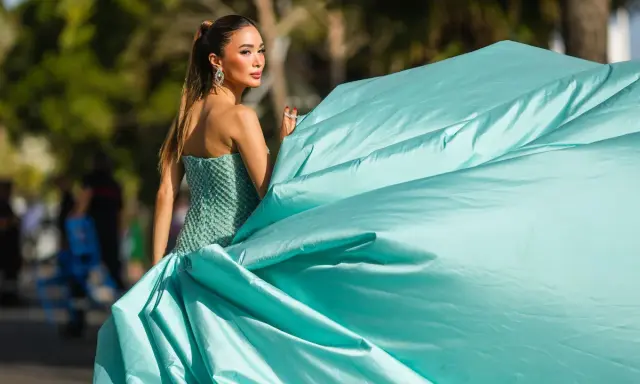 Elegante Dame im mintgrünen Ballkleid, das den Black Tie Dresscode für Damen perfekt verkörpert. Ihr Kleid weht im Wind.
