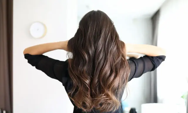 Frauenhaar mit butterfly haircut mittellang, wellig und braun.