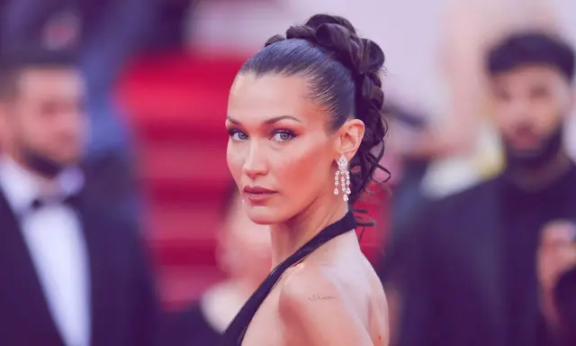 Bella Hadid präsentiert einen eleganten, sleek zopf mit funkelnden Ohrringen auf dem roten Teppich.