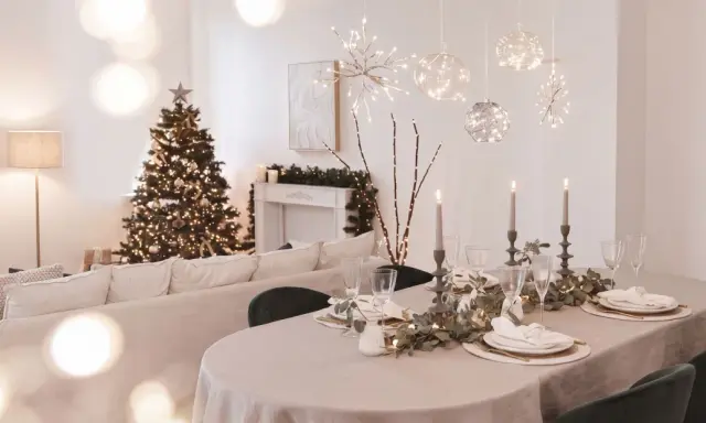 Festlich gedeckter Tisch mit Kerzen und Weihnachtbaum. Die Frage "ab wann weihnachtsdeko" stellt sich hier nicht, denn die Deko ist bereits da!