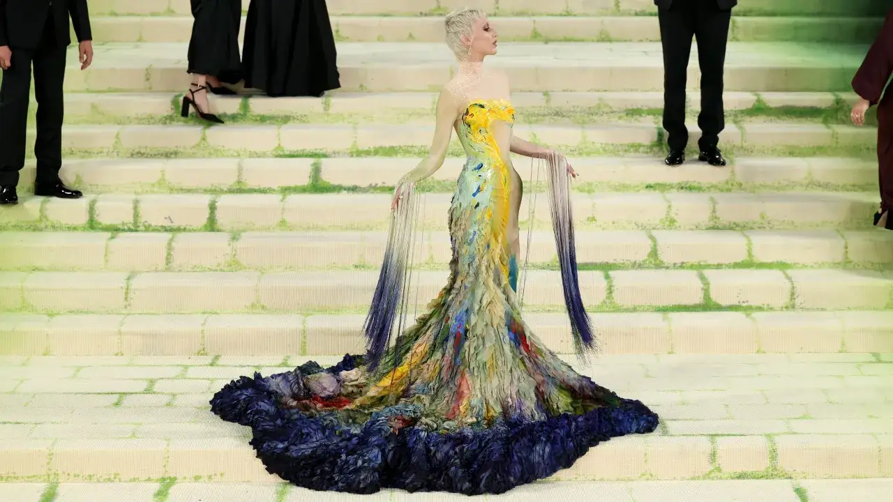 K&uuml;nstlerin pr&auml;sentiert ein farbenpr&auml;chtiges, skulpturales Kleid mit Federn und Quasten auf der Met Gala 2026.